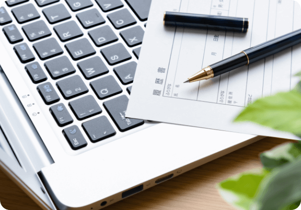 ノートパソコンと履歴書の画像