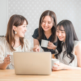 パソコンを見ながら談笑する学生の様子