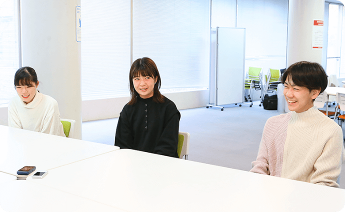 机を挟んで談笑する学生たちの様子