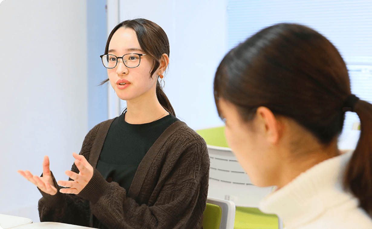 机を挟んで談笑する学生たちの様子