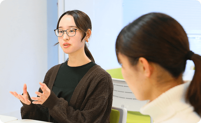 机を挟んで談笑する学生たちの様子