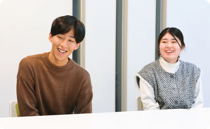 机を挟んで談笑する学生たちの様子