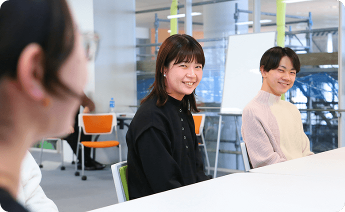 机を挟んで談笑する学生たちの様子