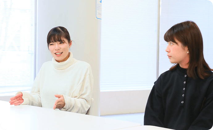 机を挟んで談笑する学生たちの様子