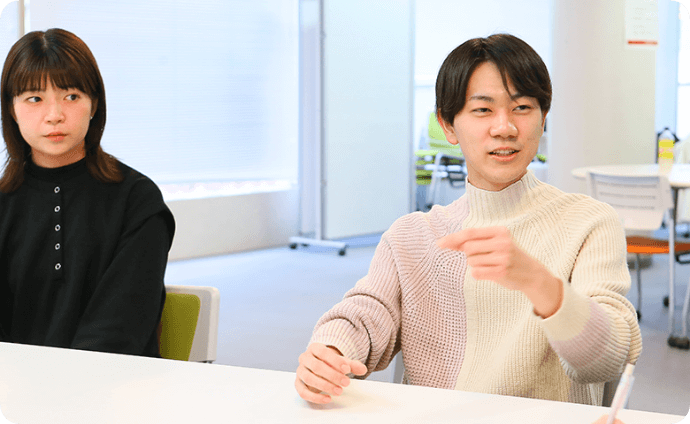 机を挟んで談笑する学生たちの様子